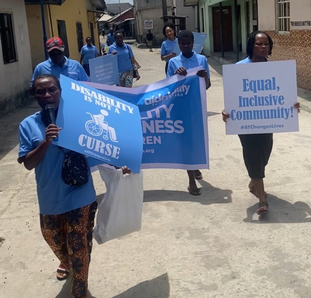 A group of people marching with inclusion signs.